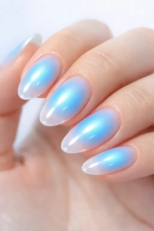 Close up macro photograph of a woman's hand displaying dreamy pastel blue aura nails