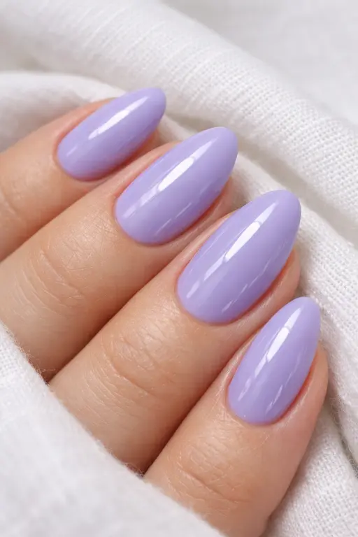 Close up macro photograph of a woman's hand with a smooth, glossy classic lavender gel manicure